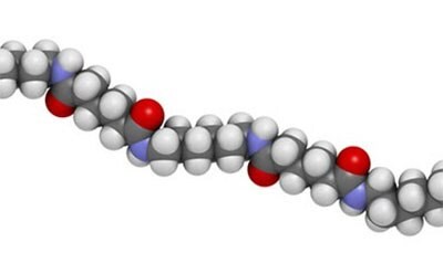 Chemical structure of nylon plastic polymer with atoms represented as spheres in conventional color coding: hydrogen (white), carbon (grey), oxygen (red). Nylon (nylon-6,6) plastic polymer, chemical structure - linear fragment. 