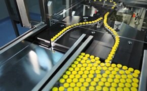 Conveyor belts in a factory with a stream of yellow bottle caps moving along them, highlighting the efficiency and automation in manufacturing Conveyor belts in a factory with a stream of yellow bottle caps moving along them, highlighting the efficiency and automation in manufacturing