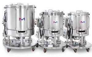 Three stainless steel bioreactor vessels of varying sizes on wheeled stands, each with a blue and pink ‘M’ logo on the front.