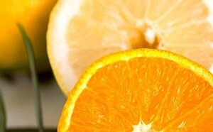 A vibrant close-up of a juicy, sliced orange with a contrasting slice of lemon in the background, highlighting the fresh and appetizing texture of the citrus fruits.