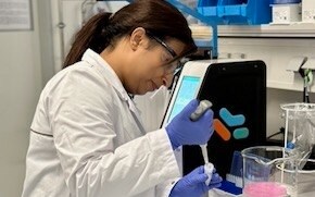 Aditi는 실험실에서 PPE를 착용하고 피펫을 사용하여 용액을 추출하고 있습니다.