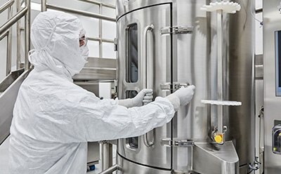AAV Platform Manufacturing operator in PPE operates a 1,000L single-use bioreactor during AAV production