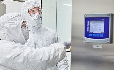 Adenovirus Capabilities Two manufacturing operators in PPE review settings during adenovirus production