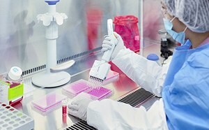 CTDMO Shangai BioSafety profession in PPE gear taking samples with pipette.