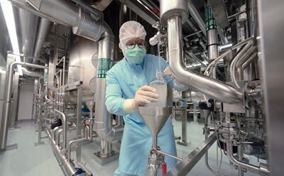 Manufacturing and custom packaging capabilities in over 45 manufacturing sites worldwide Manufacturing worker in a production area with pipes