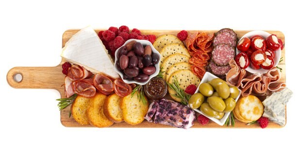 Displayed on a charming wooden board equipped with a convenient handle, the charcuterie platter presents a delightful assortment of savory delicacies. The carefully curated selection includes a variety of preserved meats, enticing olives, flavorful peppers, luscious berries, crisp crackers, and an array of delectable cheeses.