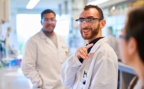 Professionals smiling in lab coats in a lab setting